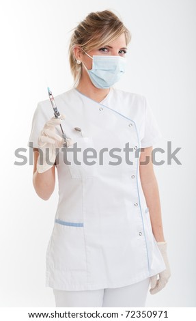 Attractive blonde female dentist holding a syringe