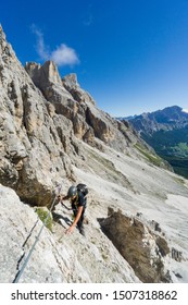 attractive blonde female mountain climber on a steep Via Ferrata above Cortina d'Ampezzo