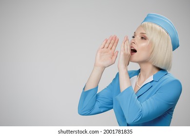 Attractive Blonde Flight Attendant Makes An Announcement Using Her Hands As A Loudspeaker. Gray Background.