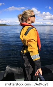 Attractive Blonde Girl At Sea Wearing A Dry Suit And Life Jacket