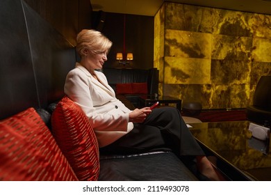 Attractive Blonde Lady Passing Time In Hotel Lounge