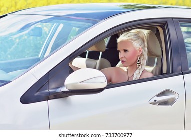 Attractive Blonde Woman Driving A Car With The Window Down