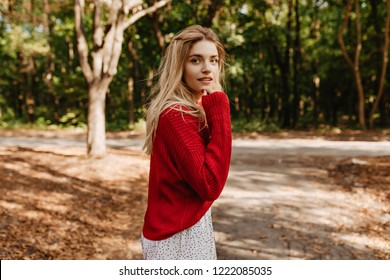 Attractive Blonde Woman Looking Playfully Into The Camera. Pretty Girl With Natural Make-up And Comfy Mod Style.