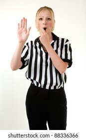 Attractive Blonde Woman Wearing Black And White Striped Referee Uniform Blowing On A Whistle Making A Hand Signal