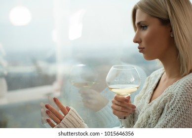 Attractive Blonde Women Drinking Wine By A Window.