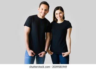 Attractive boyfriend and girlfriend wearing black matching t-shirts. Beautiful couple with custom print t-shirts