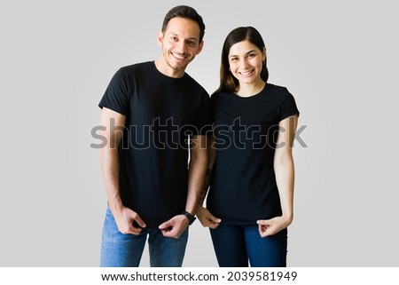 Attractive boyfriend and girlfriend wearing black matching t-shirts. Beautiful couple with custom print t-shirts