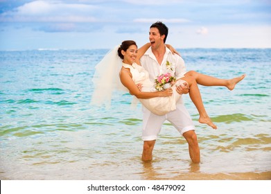 An attractive bride and groom getting married by the beach