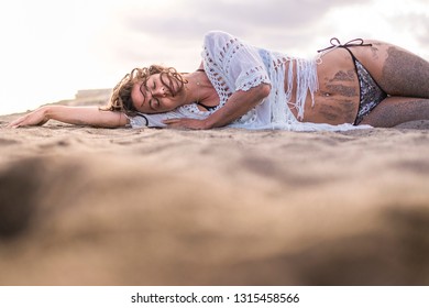 Attractive Brunete Lay Down With Closed Ayes At The Beach On The Sand With Bikini And Happy Expression - Sexy Beautiful Girl Enjoying Summer Vacation - Wonderlust Traveler Concept For Young People