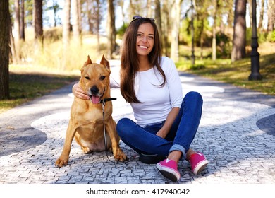 Attractive Brunette Female Posing With Her Dog On A Road In A Spring Nature Par.