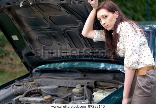 attractive brunette in front of her car broken\
down car, assistance\
concept