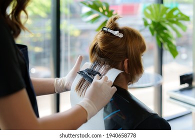 Attractive brunette hairdresser thoroughly dyeing hair of female client while she is sitting in chair in beauty salon
 - Powered by Shutterstock