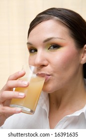 attractive brunette woman drinking orange juice