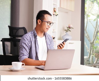 Attractive Business Asian Man Working With Computer Laptop On Wooden Table At Home. Analyzing Online Data To Success Business