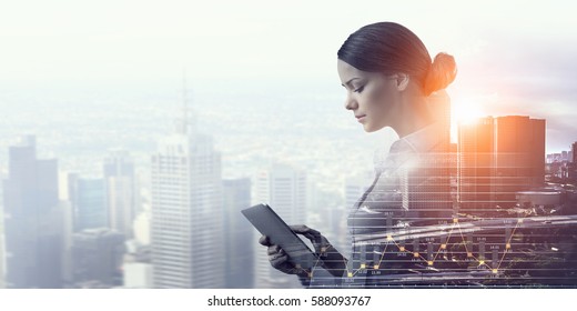 Attractive business lady working on tablet    . Mixed media - Shutterstock ID 588093767