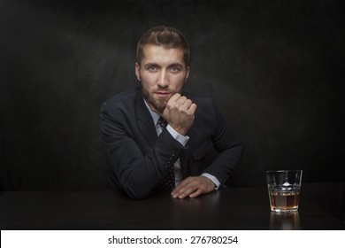 Attractive Business Man With A Glass Of Whiskey On A Black Background