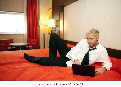 Attractive Business Man On His Laptop In Bed