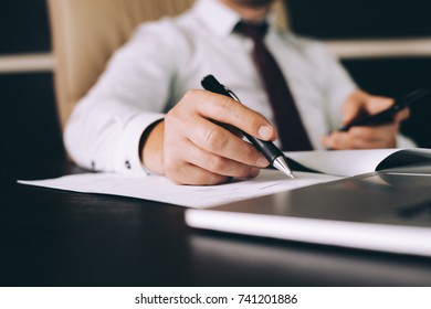 Attractive business man in smart casual wear sitting at his working place in office - Shutterstock ID 741201886