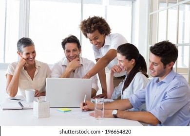 Attractive business people laughing and discussing at a business meeting