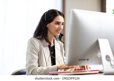 Attractive Business Woman In Suits And Headsets Are Smiling While Working With Computer At Office. Customer Service Assistant Working In One Stop Service Office