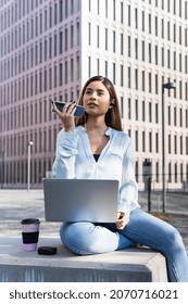 Attractive Business Woman Working With Laptop, Earphones And Smart Phone While Sitting Outdoors