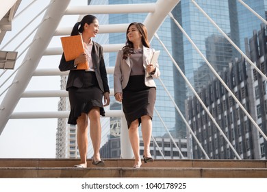 Attractive business women walking and talking outside office.