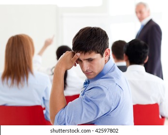 Attractive Businessman Bored At A Conference With His Colleagues