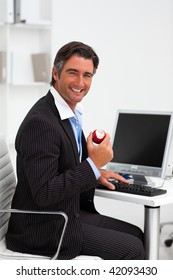 Attractive Businessman Eating An Apple In An Office