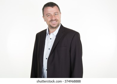 Attractive Businessman In His 40s Wearing A Black Suit With No Tie. White Background.