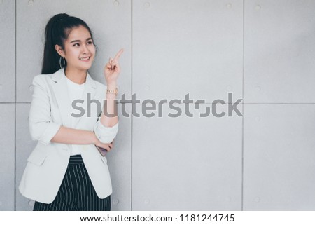 Attractive Businesswoman is smiling and standing in front of the office. Free space for text