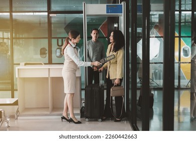 Attractive businesswoman walking with luggage through a checkpoint before boarding a plane at the terminal.