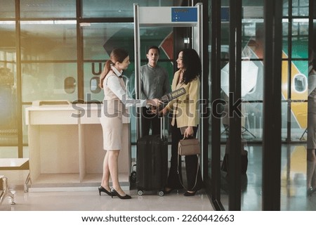 Attractive businesswoman walking with luggage through a checkpoint before boarding a plane at the terminal.
