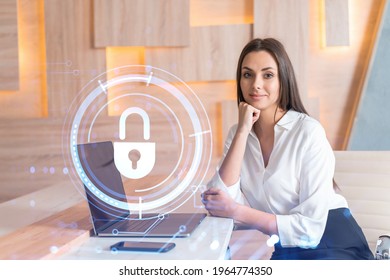 Attractive Businesswoman In White Shirt At Workplace Working With Laptop To Defend Customer Cyber Security. Concept Of Clients Information Protection. Padlock Hologram Over Office Background.