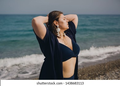 Attractive Busty Curvy Woman In A Blue Swimsuit Resting On The Beach. Stylish Accessories, Fringe, Fashion For Plus Size, Beautuful Sea.  