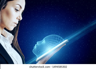 Attractive caucasian businesswoman holding tablet with glowing head outline on dark background. AI and technology concept