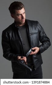 Attractive Caucasian Male With Brown Hair – Action Hero Wearing Leather Jacket And Jeans, Holding Gun