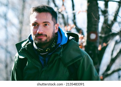 Attractive Caucasian Male Hiking In Forest. Head Shot Of Young Hiker Posing In Front Of Trail Path Mark. 