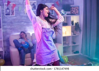 Attractive Caucasian Woman Dancing Alone At The Party. Tired Friends.