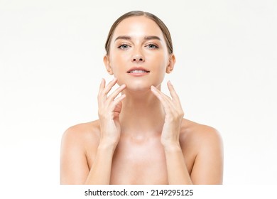 Attractive Caucasian woman massaging face on white isolated background during skincare routine in studio