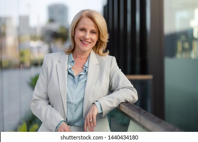 Attractive CEO older business woman executive portrait pose, standing outside workplace downtown 