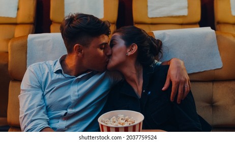 Attractive cheerful young caucasian couple kissing romantic moment while watching film in movie theater. Lifestyle entertainment concept. - Powered by Shutterstock