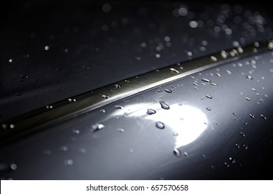 Attractive Close up of Water Drops on glossy surface car roof background. Multiple exposure lighting style