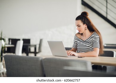 Attractive Concentrated Adult Woman Browsing The Internet And Searching Information For Business During Lunchtime.