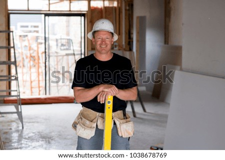 attractive and confident constructor carpenter or builder man in protective hardhat posing happy working in industrial construction job concept and installation and renovation work industry