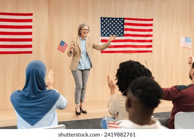 Attractive confident senior woman, politician, presidential candidate holding American flag giving a speech and crowd applaud. Vote, US presidential election campaign concept  - Powered by Shutterstock