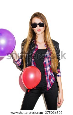 Attractive cool blonde teenage girl in black leather jacket, black pants, red checkered shirt and sunglasses. Beautiful young woman posing, balloons falling around her, isolated on white, retouched.