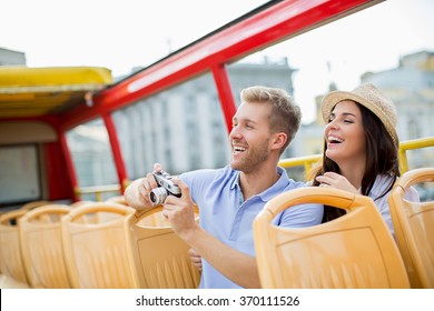 Attractive couple with camera in a tour bus