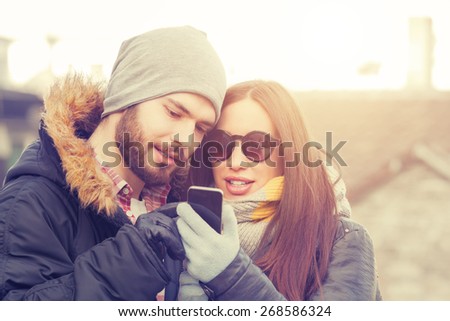 Attractive couple doing selfie outdoors.