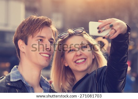 Similar – couple taking selfie in the street