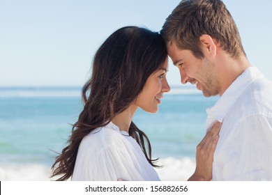 Attractive couple embracing on the beach on a sunny day - Powered by Shutterstock
